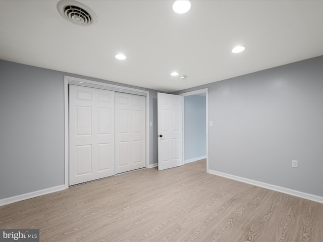 unfurnished bedroom with wood finished floors, visible vents, and baseboards