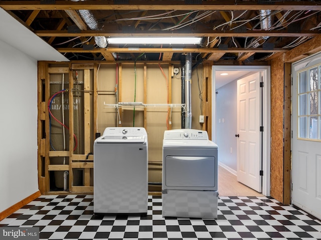 washroom featuring tile patterned floors, baseboards, laundry area, and washing machine and clothes dryer