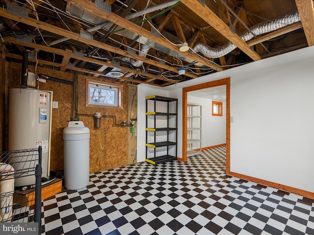 basement with tile patterned floors, baseboards, and water heater