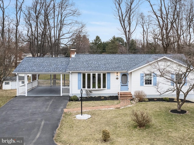 single story home with a shingled roof, a front lawn, aphalt driveway, a chimney, and a carport