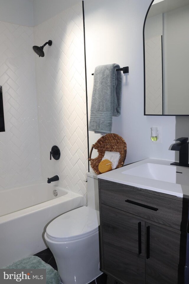 full bathroom featuring tiled shower / bath combo, vanity, and toilet