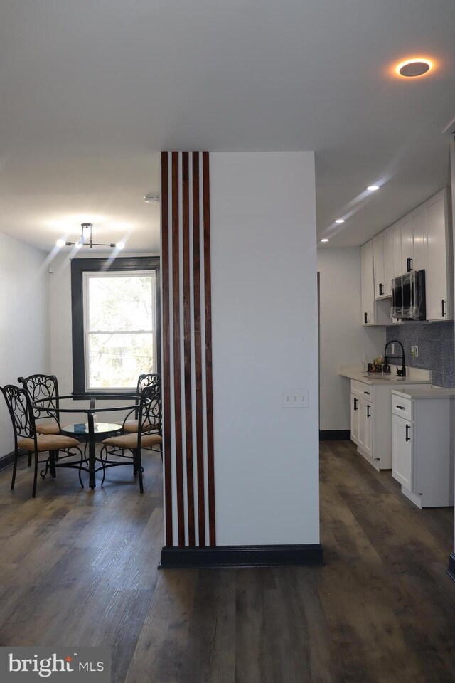 kitchen featuring dark hardwood / wood-style floors, white cabinetry, and tasteful backsplash