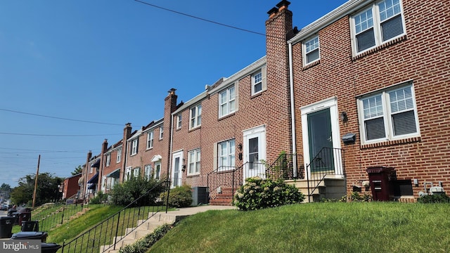 view of front facade featuring central air condition unit and a front yard