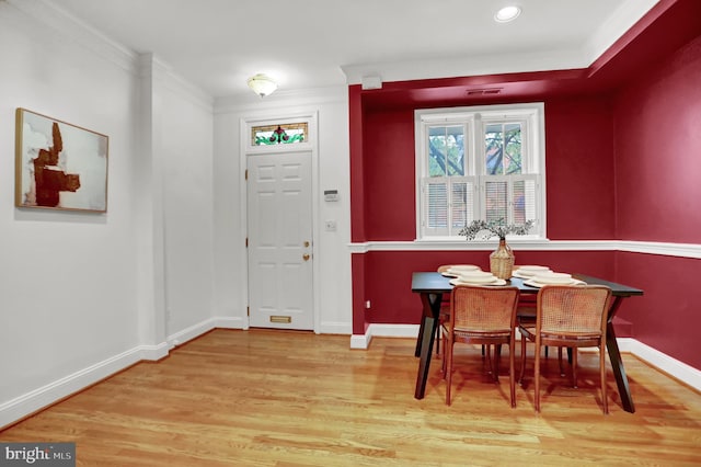 dining space with hardwood / wood-style flooring and crown molding