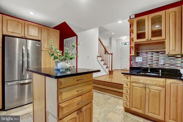 kitchen with decorative backsplash, stainless steel fridge, sink, and a kitchen island