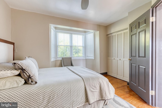 bedroom with a closet, light hardwood / wood-style floors, and ceiling fan