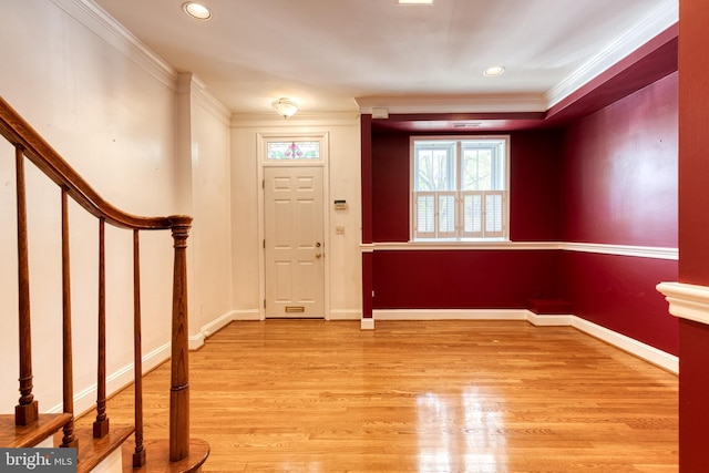 foyer featuring ornamental molding and light wood-type flooring