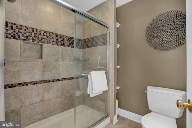 bathroom featuring tile patterned floors, toilet, and a shower with door