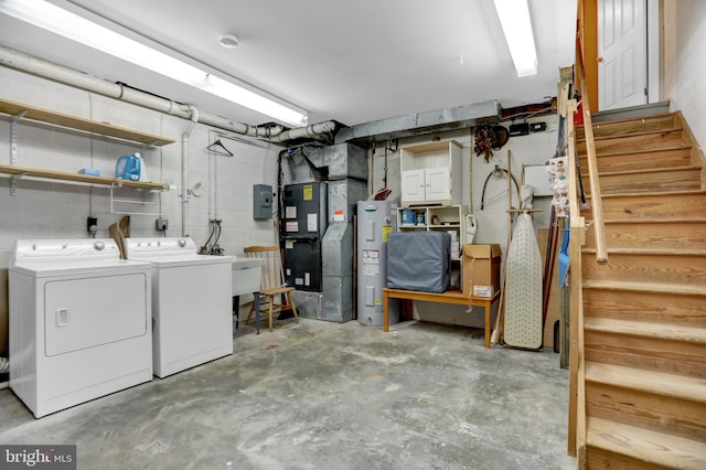 basement featuring heating unit, water heater, and washing machine and clothes dryer