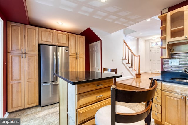 kitchen with a center island, sink, and stainless steel fridge