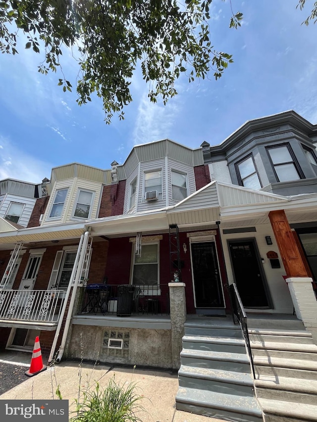 townhome / multi-family property featuring a porch and cooling unit