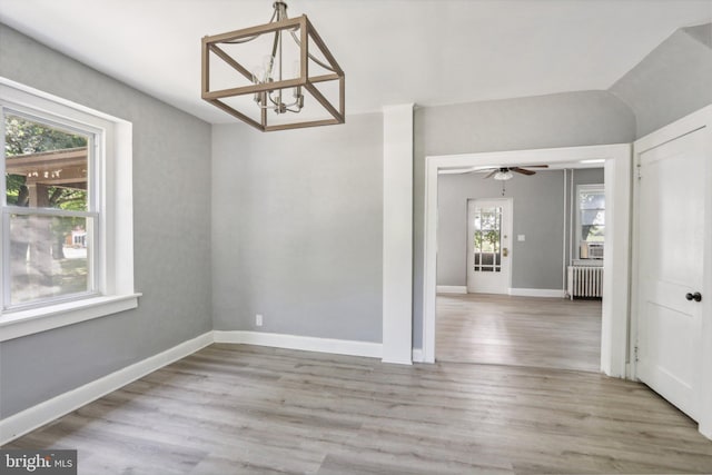 unfurnished dining area featuring radiator heating unit and light hardwood / wood-style floors