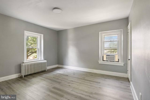 spare room with cooling unit, radiator, and light hardwood / wood-style floors