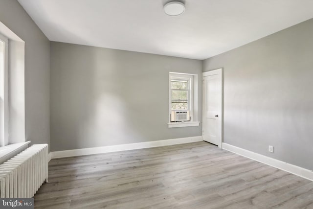 empty room with radiator and light hardwood / wood-style flooring