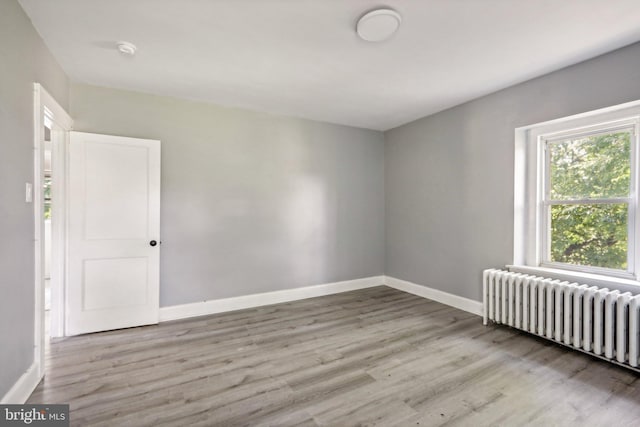 spare room with radiator and light hardwood / wood-style floors