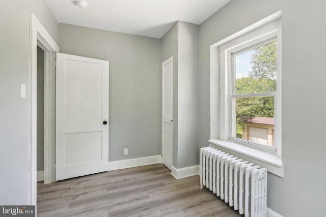 corridor with radiator and light wood-type flooring