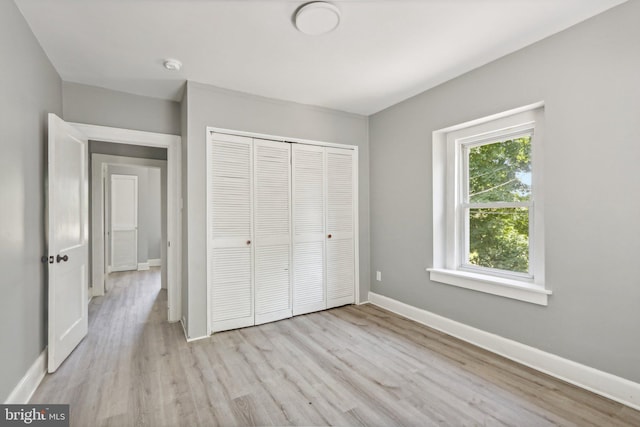 unfurnished bedroom featuring a closet and light wood-type flooring