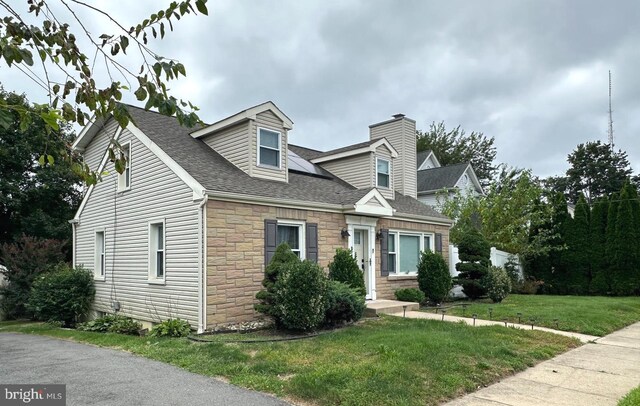 new england style home featuring a front yard