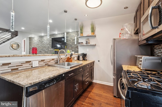 kitchen featuring sink, hanging light fixtures, stainless steel appliances, tasteful backsplash, and light stone countertops