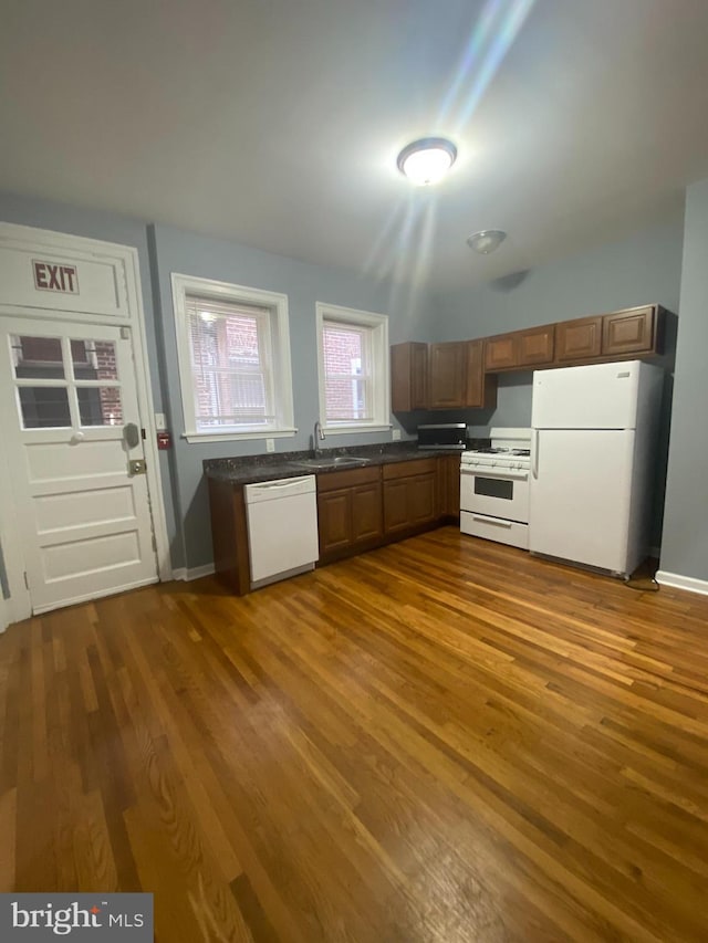 kitchen with white appliances, sink, and dark wood-type flooring