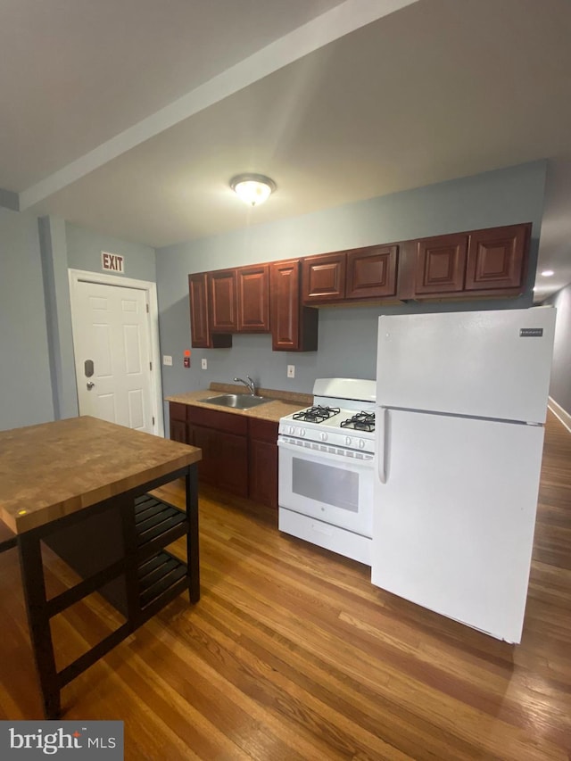 kitchen with white appliances, dark wood-type flooring, and sink