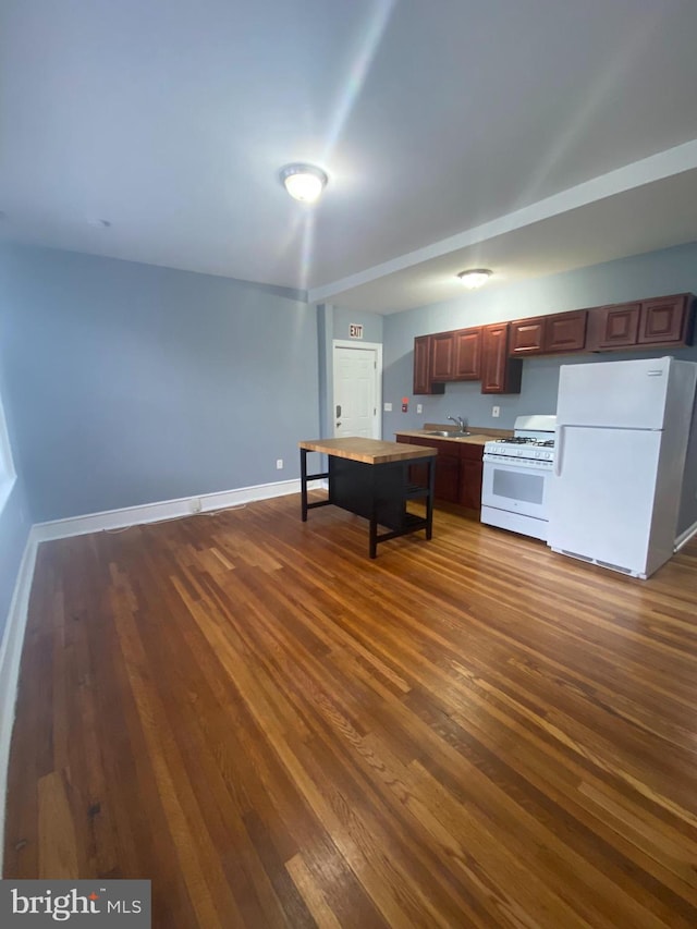 kitchen with white appliances, dark hardwood / wood-style flooring, and sink