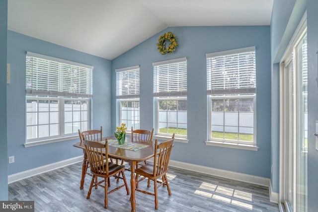 dining area featuring hardwood / wood-style floors and vaulted ceiling