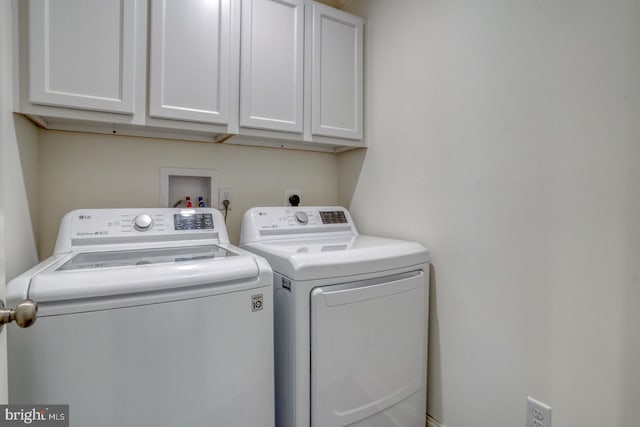 laundry area featuring washing machine and dryer and cabinets