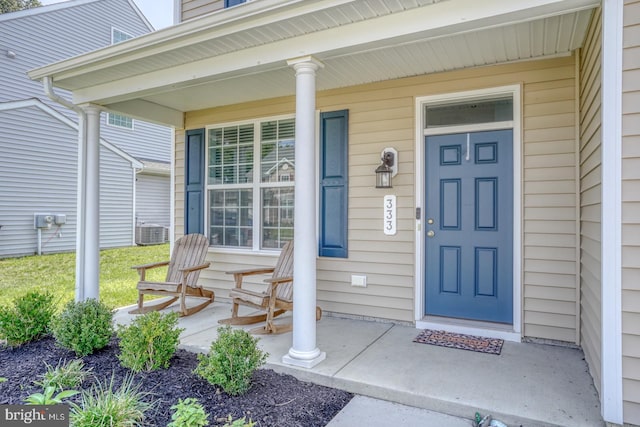 entrance to property featuring a porch and central AC