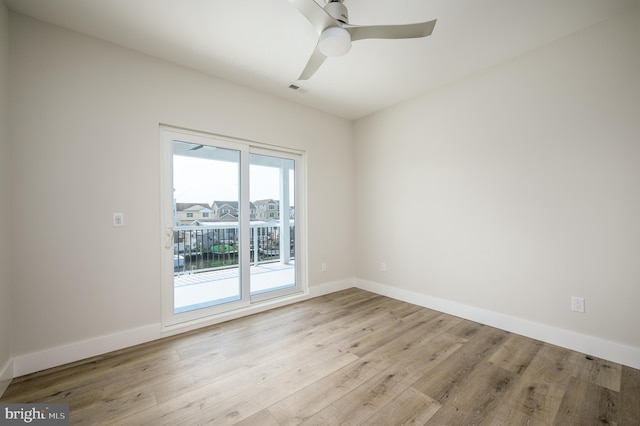 spare room with light wood finished floors, visible vents, baseboards, and a ceiling fan