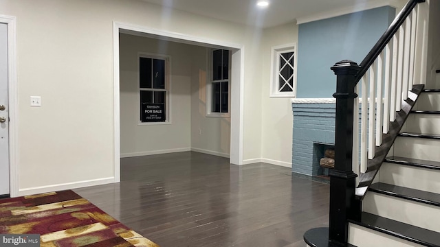 interior space with dark hardwood / wood-style floors and a brick fireplace