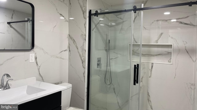 bathroom with tile walls, toilet, an enclosed shower, and vanity