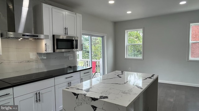 kitchen featuring wall chimney exhaust hood, dark hardwood / wood-style flooring, decorative backsplash, and a wealth of natural light