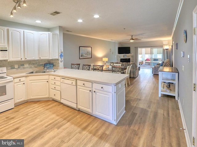 kitchen with light hardwood / wood-style floors, white cabinets, kitchen peninsula, white appliances, and ceiling fan