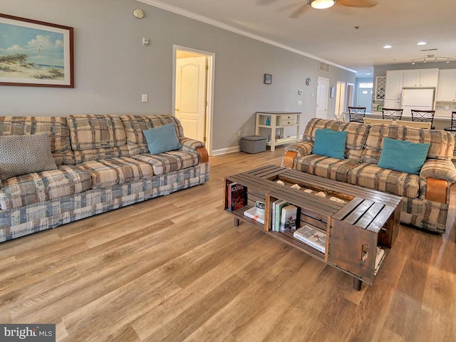 living room featuring light hardwood / wood-style flooring, ceiling fan, and ornamental molding