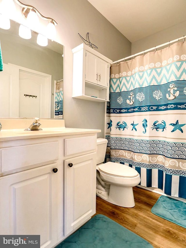 bathroom featuring wood-type flooring, vanity, and toilet