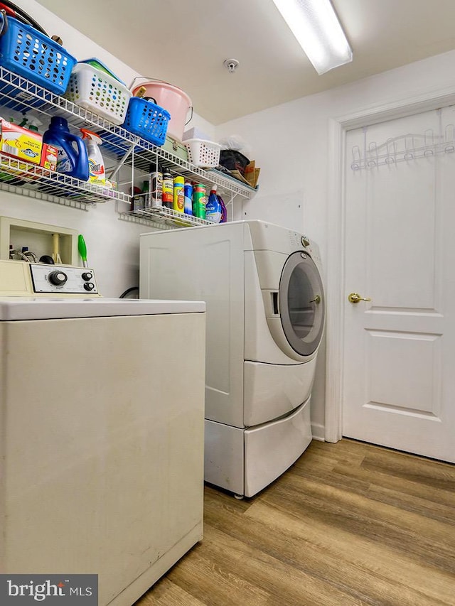 washroom featuring light hardwood / wood-style floors and washing machine and clothes dryer