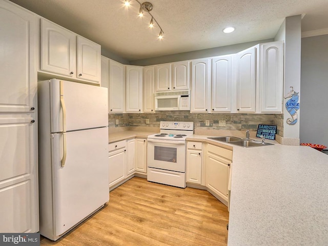 kitchen featuring tasteful backsplash, sink, white cabinetry, light hardwood / wood-style flooring, and white appliances