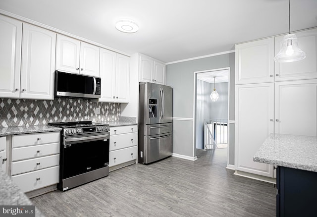 kitchen with stainless steel appliances, white cabinetry, pendant lighting, and light wood-type flooring