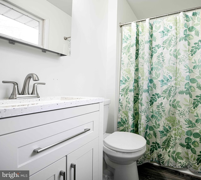 bathroom featuring hardwood / wood-style flooring, toilet, curtained shower, and sink