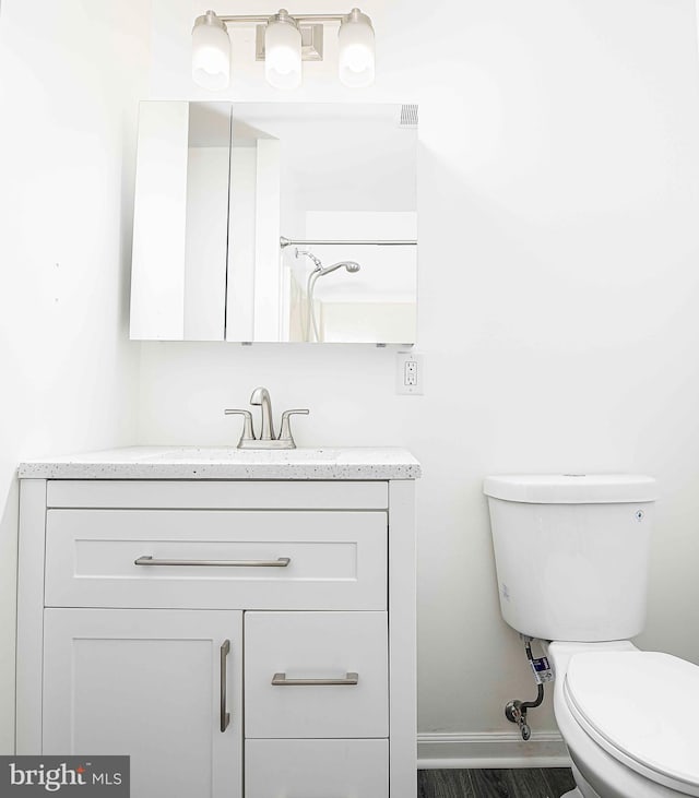 bathroom with vanity, toilet, and a shower