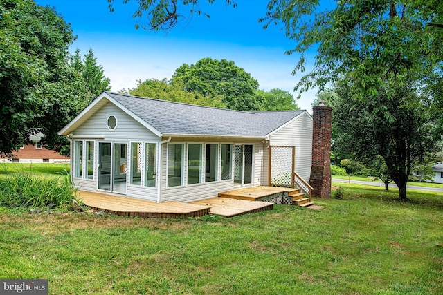 back of property with a sunroom and a lawn