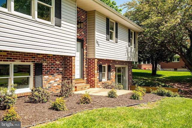 view of property exterior with a yard and a patio