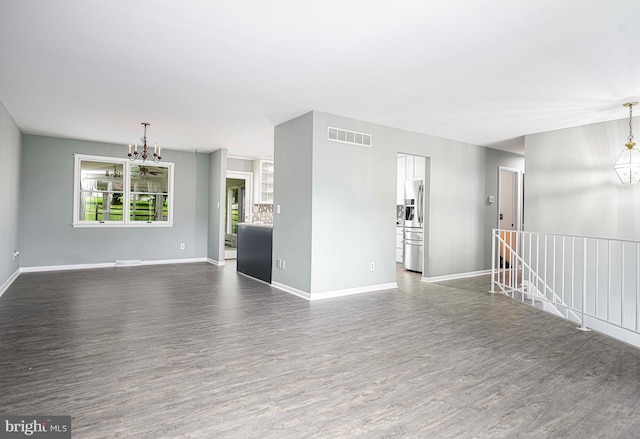 empty room with dark hardwood / wood-style flooring and a chandelier