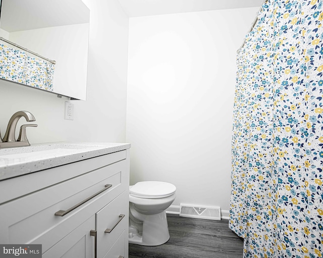 bathroom with vanity, hardwood / wood-style floors, and toilet