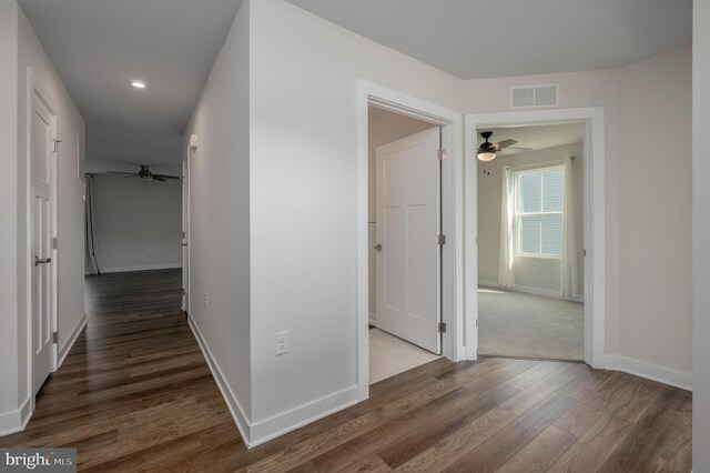 corridor featuring dark colored carpet