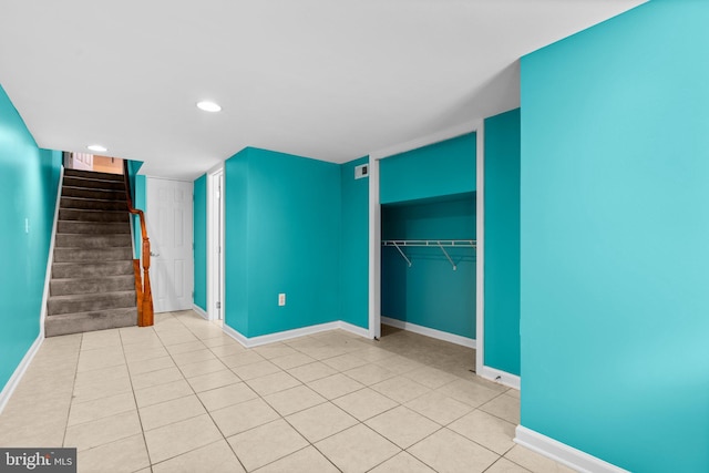 interior space with light tile patterned floors and a closet