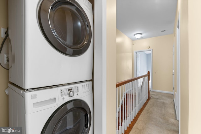 washroom featuring stacked washer / drying machine and light colored carpet