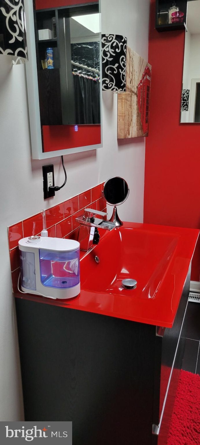 interior space featuring vanity and decorative backsplash