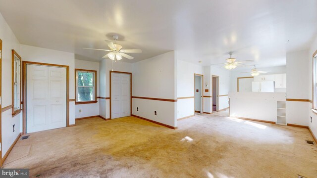 empty room with ceiling fan and light carpet